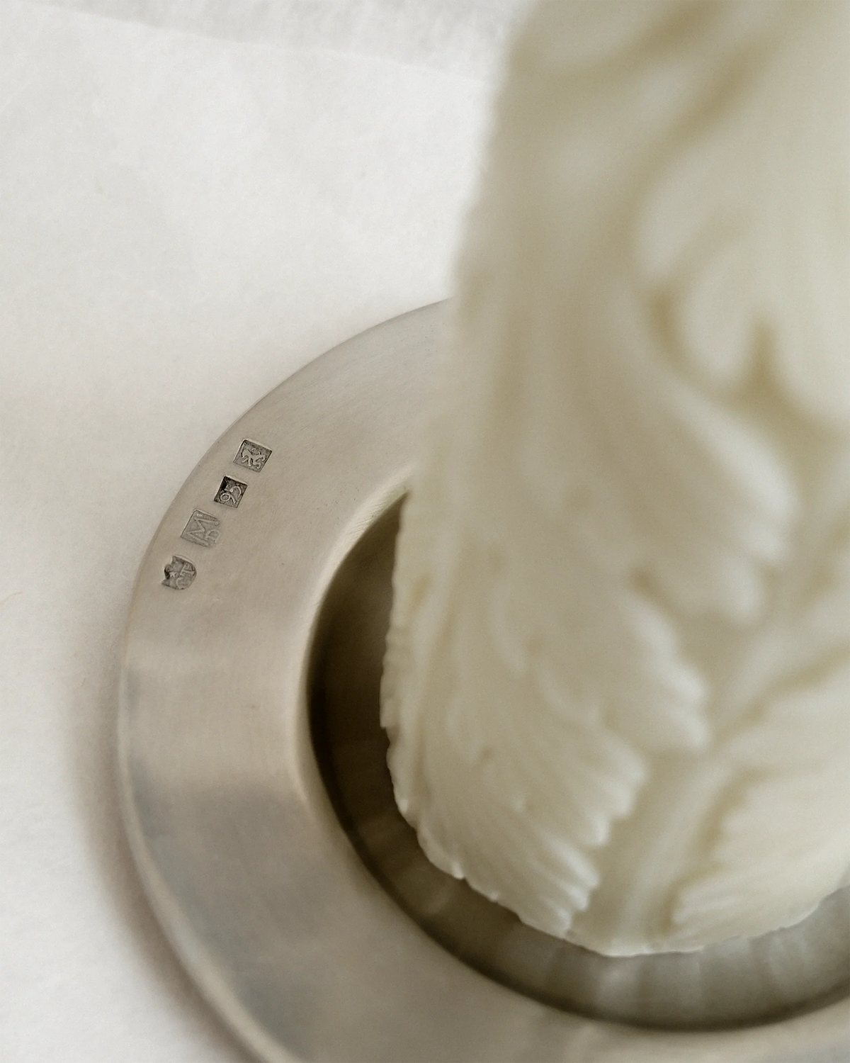Detail of the Acantha Pillar Candle’s acanthus leaf relief and maker’s marks on the pewter chamberstick.